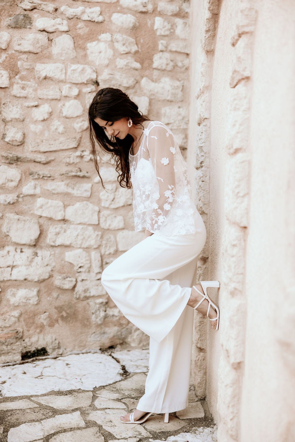 Close-up of bride in intricate lace wedding dress with sheer sleeves and soft V neckline, refined Australian bridal design with delicate detail